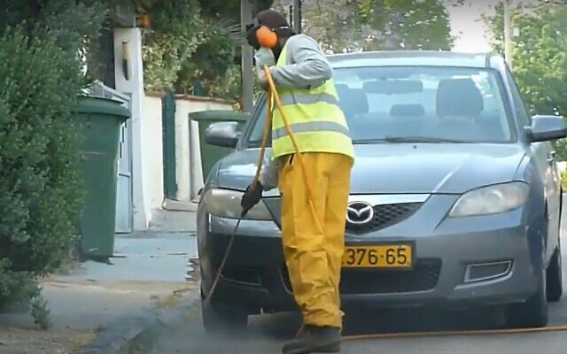 Spraying an Israeli street with weedkiller. (YouTube screenshot)