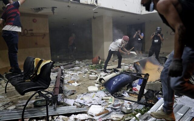 Lebanese protesters destroy the interior of the headquarters of the Lebanese association of banks in downtown Beirut on August 8, 2020, following a demonstration against a political leadership they blame for a monster explosion that killed more than 150 people and disfigured the capital Beirut. (Photo by ANWAR AMRO / AFP)