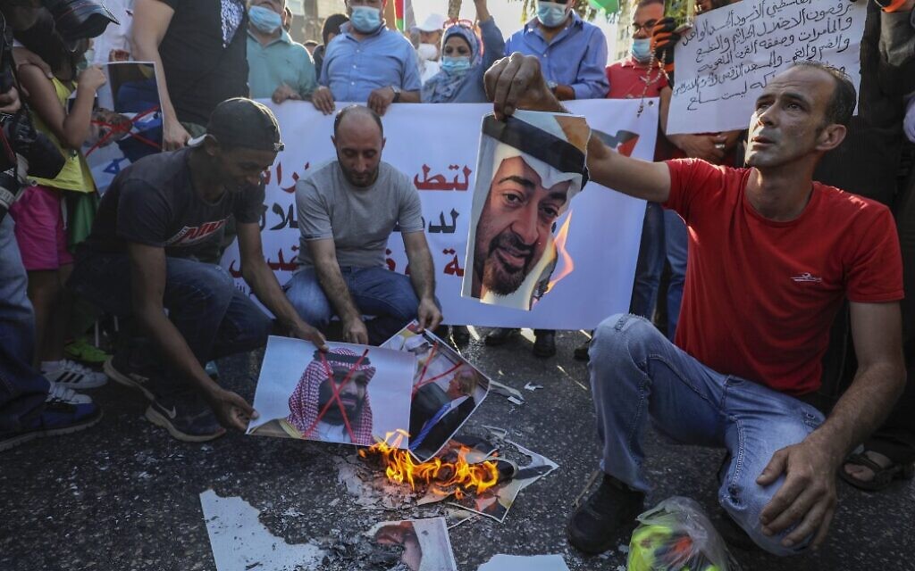 Palestinians in the West Bank city of Ramallah burn pictures of Emirati Crown Prince Sheikh Mohammed bin Zayed Al Nahyan (top) and Saudi Crown Prince Mohammed bin Salman, during a demonstration against the UAE-Israeli agreement to normalize diplomatic ties, August 15, 2020. (Abbas Momani/AFP)