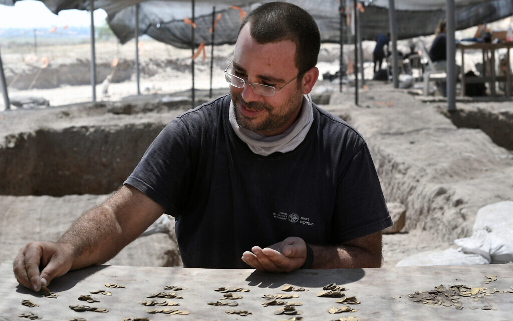 Shahar Krispin, Israel Antiquities Authority coin expert, counts the gold coins  (Yoli Schwartz, Israel Antiquities Authority)