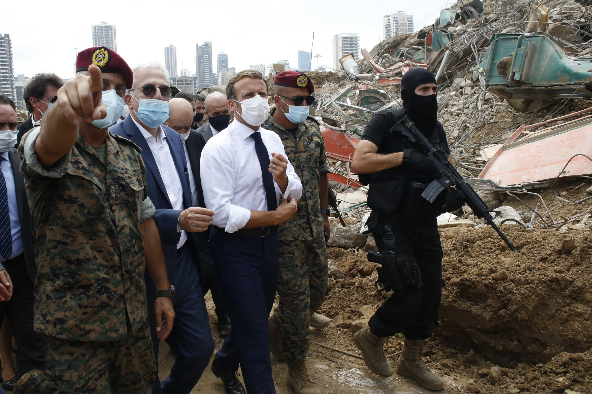 French President Emmanuel Macron, center, visits the devastated site of the explosion at the port of Beirut, Lebanon, August 6, 2020. (AP Photo/Thibault Camus, Pool)