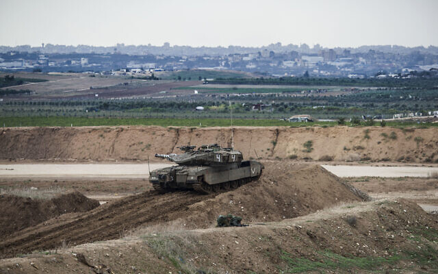Illustrative: An Israeli tank takes position on the Israel-Gaza border. (AP Photo/Tsafrir Abayov)