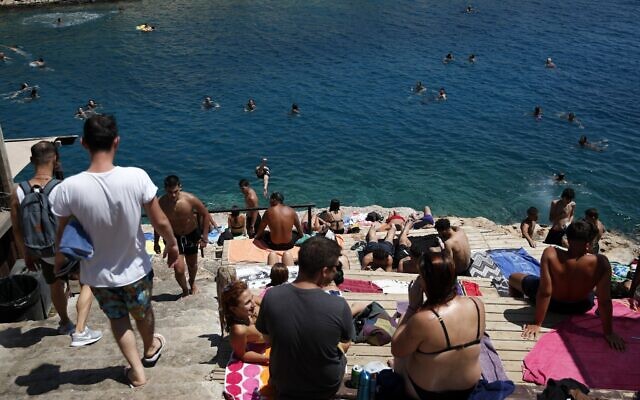 People gather in Limanakia Vouliagenis beach in southern Athens, August 6, 2020. (AP Photo/Thanassis Stavrakis)