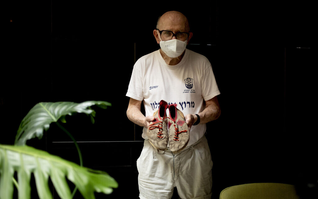 Israeli Olympic racewalker Shaul Ladany holds his 1972's Olympic race shoes for a portrait in Omer, Israel, July 12, 2020. (Ariel Schalit/AP)