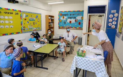 First-grade students and their parents in a classroom ahead of the opening of the school year at Orot Etzion School, in the West Bank settlement of Efrat, August 30, 2020. (Gershon Elinson/Flash90)