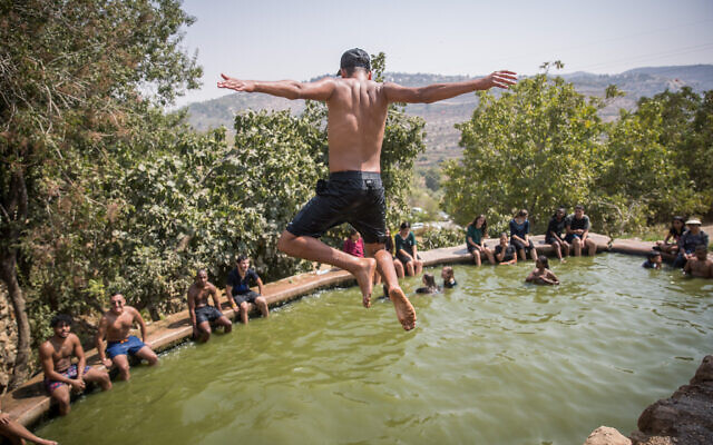 Young people enjoy a hot summer's day at the Ein Lavan Spring in the Jerusalem hills, August 30, 2020. (Yonatan Sindel/Flash90)