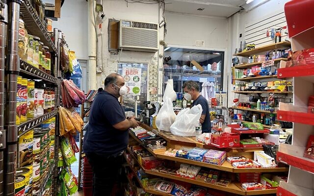 A customer checks out Israeli goods at the Holyland Market in the East Village neighborhood of Manhattan on August 11, 2020. (Jacob Magid/Times of Israel)