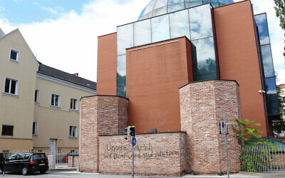 A man walks past the defaced facade of the synagogue of Graz, Austria on August 19, 2020. (Christian Jauschowetz via JTA)