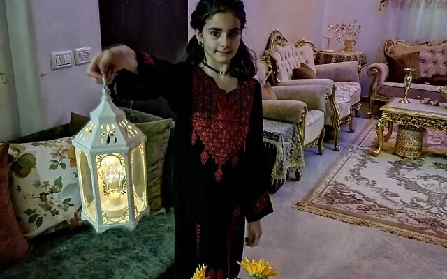 ِA member of the Abu Sbeih family of East Jerusalem honors a Ramadan tradition by holding up a lantern in their living room, prior to the family home's demolition (Iyad Abu Sbeih)