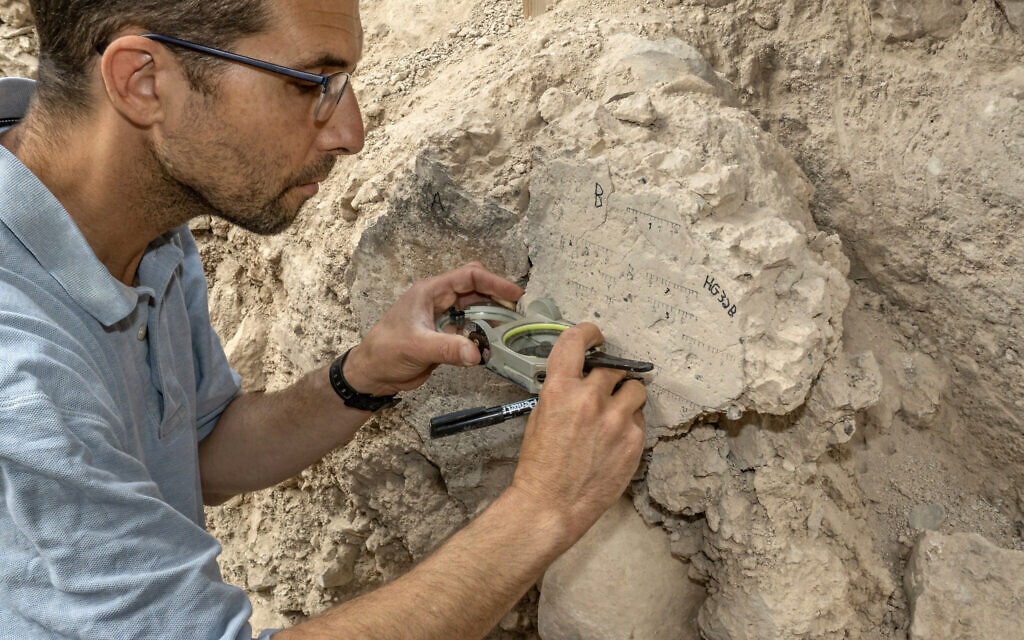 TAU PhD student Yoav Vaknin takes measurements of a floor that collapsed during the 586 BCE destruction of Jerusalem by the Babylonians at excavations in the City of David Park in Jerusalem. (Shai Halevi/Israel Antiquities Authority)