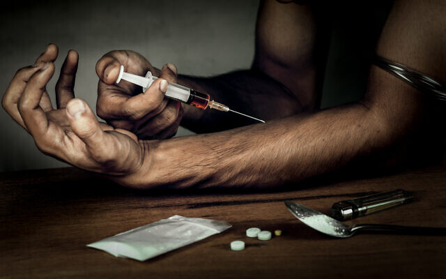 A man with a syringe used to inject heroin (iStock)
