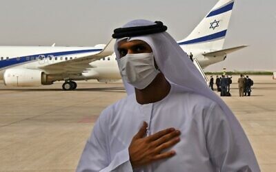 An Emirati official stands near an El Al plane that carried a US-Israeli delegation to the UAE following a normalization accord, upon its arrival at the Abu Dhabi airport, in the first-ever direct flight from Israel to the UAE, on August 31, 2020. (KARIM SAHIB / AFP)