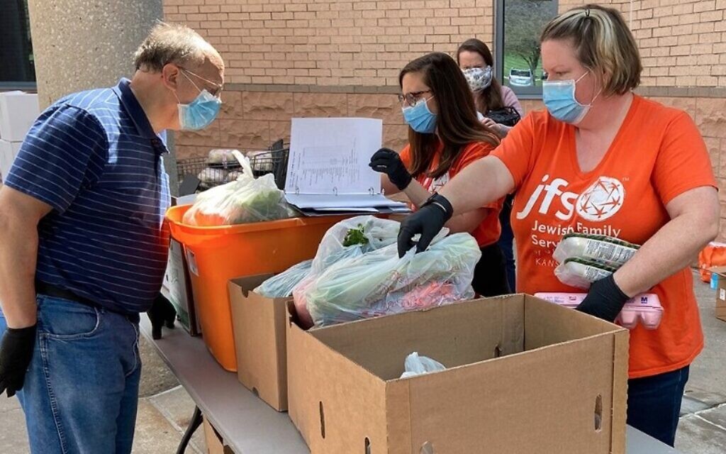 Food pantry volunteers work outside at the Jewish Federation of Kansas City amid the adoption of new pandemic-era health-and-safety protocols by Jewish institutions around the country. (Courtesy of JFGKC via JTA)