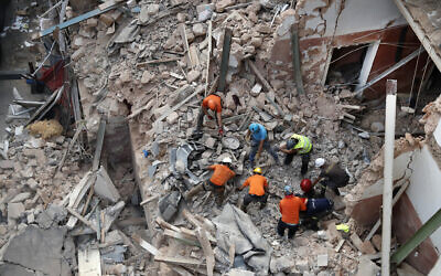Lebanese and Chilean rescuers search in the rubble of a collapsed building after getting signals there may be a survivor, early Friday, Sept. 4, 2020, in Beirut, Lebanon. A pulsing signal was detected Thursday from under the rubble of a Beirut building that collapsed during the horrific port explosion in the Lebanese capital last month, raising hopes there may be a survivor still buried there. (AP Photo/Hussein Malla)