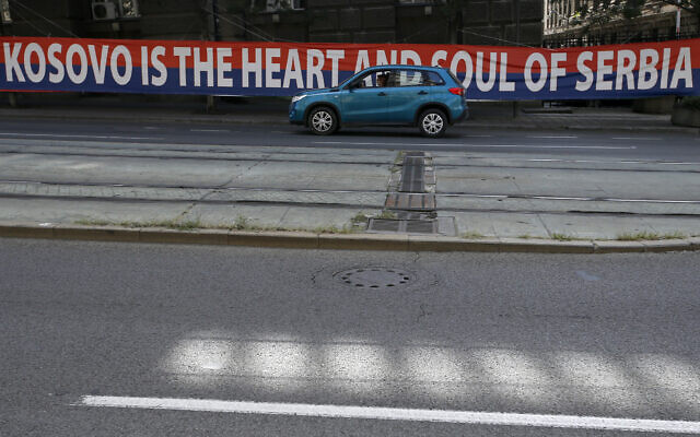 A car passes by a billboard reading: ”Kosovo is the heart and soul of Serbia” placed on a street in front of the government building in Belgrade, Serbia, Wednesday, Sept. 2, 2020. Serbian President Aleksandar Vucic and Kosovo Prime Minister Avdullah Hoti will meet at the White House on Thursday and Friday. (AP Photo/Darko Vojinovic)