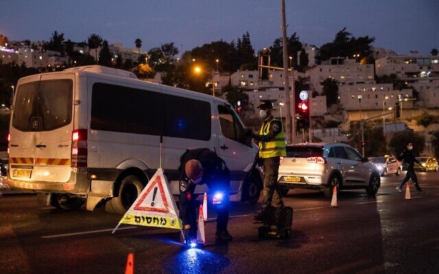Israeli police seen at the entrance to the neighborhood of Ramot in Jerusalem, as Israel enforces a night curfew, applied to some 40 cities all over Israel which have been badly affected by the coronavirus, September 9, 2020. (Yonatan Sindel/ Flash90)