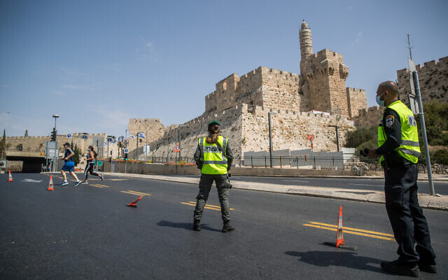 Police at a temporary checkpoint on a nearly empty road outside Jerusalem's Old City on September 19, 2020, during a nationwide coronavirus lockdown. (Yonatan Sindel/Flash90)