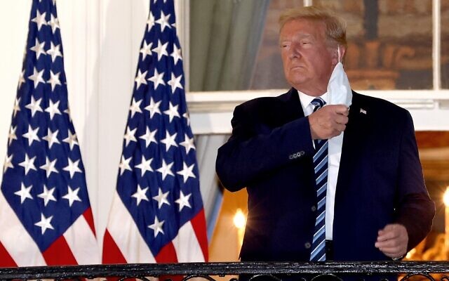 US President Donald Trump removes his mask upon his return to the White House from Walter Reed National Military Medical Center on October 5, 2020, in Washington, DC. (Win McNamee/Getty Images/AFP)