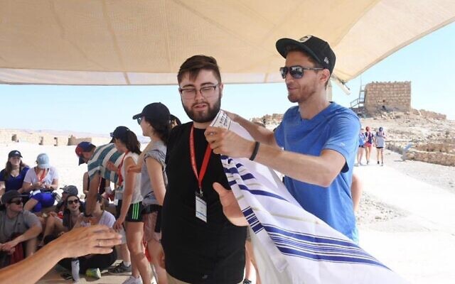 Justin Christopher Tobin, seen here wearing a tallit during a Birthright trip, says El Al agents interrogated him about his middle name ahead of his visit to Israel. (Courtesy of Tobin/ via JTA)