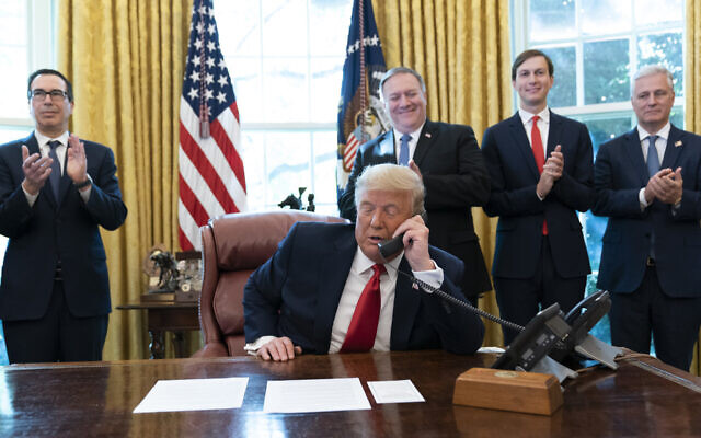US President Donald Trump talks on a phone call with the leaders of Sudan and Israel, as Treasury Secretary Steven Mnuchin, left, Secretary of State Mike Pompeo, White House senior adviser Jared Kushner, and National Security Adviser Robert O'Brien, applaud in the Oval Office of the White House, Oct. 23, 2020, in Washington. (AP/Alex Brandon)