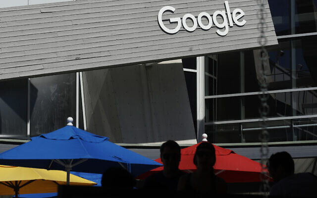 In this Sept. 24, 2019, file photo people walk by a Google sign on the campus in Mountain View, California (AP Photo/Jeff Chiu, File)