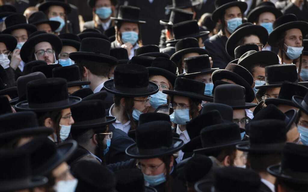 Haredi Jews from the Hasidic sect of Shomrei Emunim attend the funeral of Rabbi Refael Aharon Roth, 72, who died from the coronavirus, in Bnei Brak, Israel, August 13, 2020. (AP Photo/Oded Balilty)
