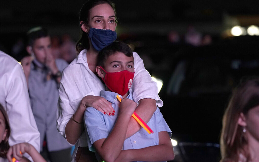Illustrative: A woman stands with her son during a Yom Kippur service hosted by the Aventura Turnberry Jewish Center, during the coronavirus pandemic, Monday, Sept. 28, 2020, at the Dezerland Park drive-in theatre in North Miami, Fla. (AP Photo/Lynne Sladky)