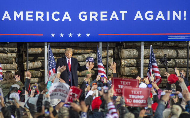 US President Donald Trump stands in front of supporters against a backdrop of a logging truck at Duluth International Airport on Wednesday, Sept. 30, 2020, in Duluth, Minn. (AP Photo/Jack Rendulich)