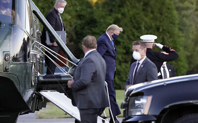US President Donald Trump arrives at Walter Reed National Military Medical Center, in Bethesda, Md., Oct. 2, 2020, on Marine One helicopter after he tested positive for COVID-19. White House chief of staff Mark Meadows is at left. (AP Photo/Jacquelyn Martin)