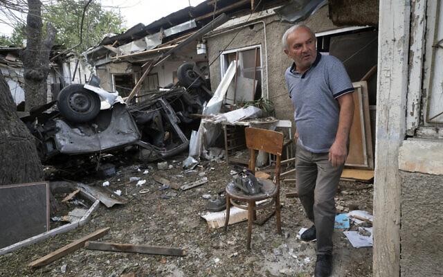 A man walks in the yard of a house destroyed by shelling by Azerbaijan's artillery during a military conflict in Stepanakert, the separatist region of Nagorno-Karabakh, Oct. 9, 2020 (AP Photo)