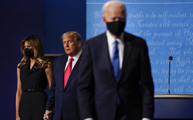 US First lady Melania Trump, left, and US President Donald Trump, center, remain on stage as Democratic presidential candidate former Vice President Joe Biden, right, walk away at the conclusion of the second and final presidential debate, October 22, 2020, at Belmont University in Nashville, Tennessee. (AP Photo/Julio Cortez)