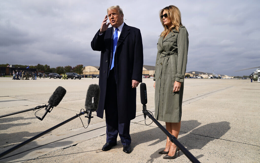 US President Donald Trump talks to reporters as first lady Melania Trump listens before boarding Air Force One for a day of campaign rallies in Michigan, Wisconsin, and Nebraska, October 27, 2020, at Andrews Air Force Base, Maryland. (AP Photo/Evan Vucci)