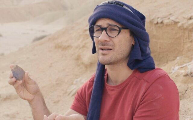 Dr. Filipe Natalio, seen here at a site in the Negev Desert, holding a flint tool. (screenshot)