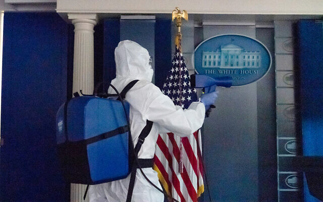 Cleaning staff disinfects The James Brady Briefing Room of the White House, Oct. 5, 2020. (AP Photo/Alex Brandon)