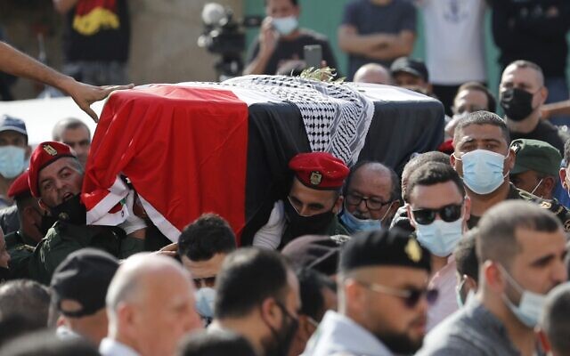 Palestinian mourners and an honor guard carry the coffin of late Palestinian negotiator Saeb Erekat during his funeral procession in the West Bank city of Jericho on November 11, 2020 (Ahmad GHARABLI / PPO / AFP)
