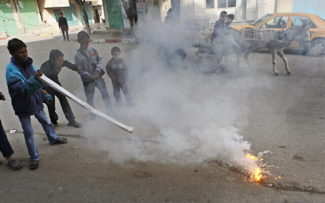 Children play with a flaming lump, allegedly containing white phosphorus, on a street in the town of Beit Lahiya, in the northern Gaza strip, January 19, 2009. (AP Photo/Ben Curtis, File)