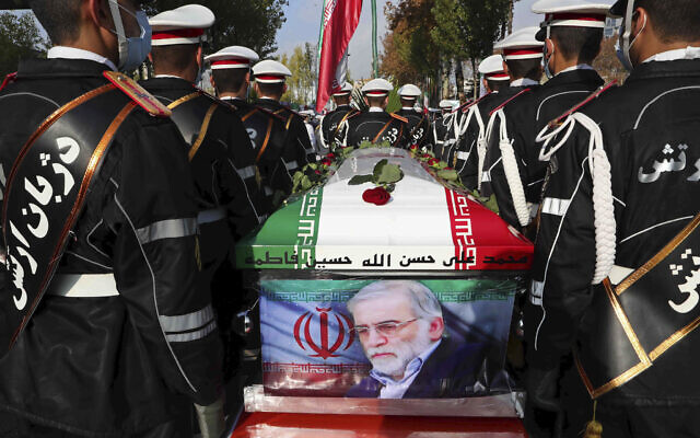 Military personnel stand near the flag-draped coffin of Mohsen Fakhrizadeh, during a funeral ceremony in Tehran, Iran, November 30, 2020. (Iranian Defense Ministry via AP)