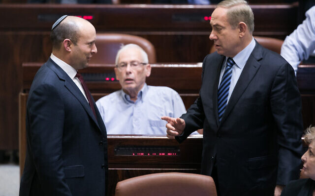 Prime Minister Benjamin Netanyahu, right, speaks with then Education Minister Naftali Bennett during a plenum session in the Knesset, on December 5, 2016. (Yonatan Sindel/Flash90)