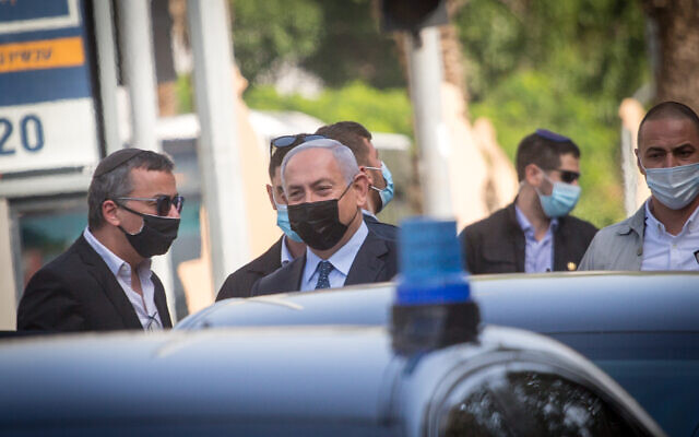 Prime Minister Benjamin Netanyahu is seen surrounded by security personnel during an unscheduled visit to the Tel Aviv suburb of Givatayim, November 9, 2020. (Miriam Alster/Flash90)