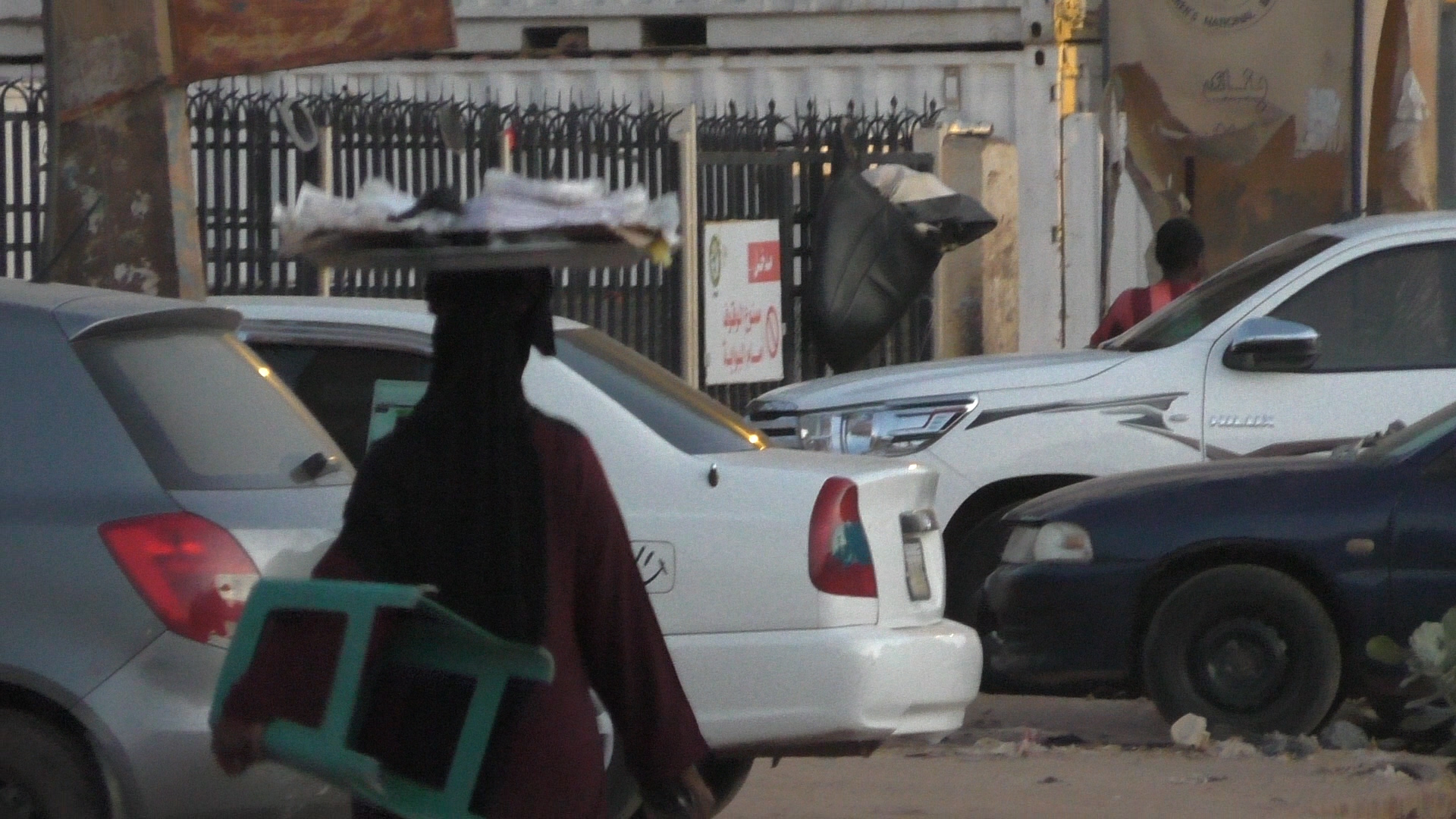 A woman carrying a tray on her head in Khartoum, Sudan, November 2020. (Ziv Genesove)