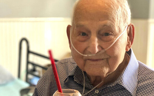 In this photo provided by Holly Wooten McDonald, World War II veteran and COVID-19 survivor Major Wooten holds a celebratory milkshake on his 104th birthday on Thursday, Dec. 3, 2020, in Madison, Alabama. Wooten was released from the hospital this week after contracting the illness caused by the new coronavirus before Thanksgiving. (Holly Wooten McDonald via AP)