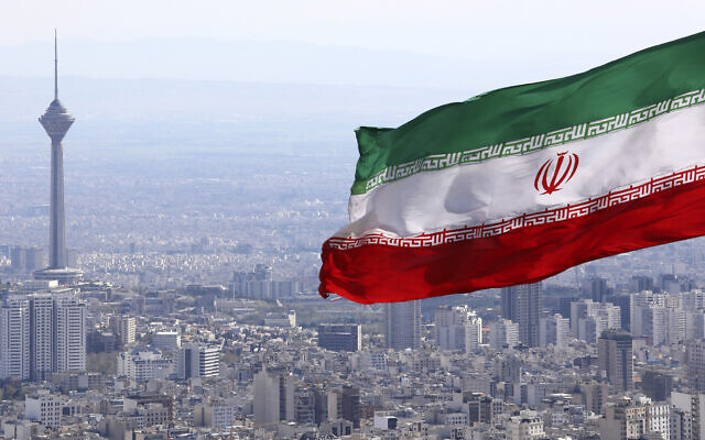In this March 31, 2020, file photo, Iran's national flag waves as Milad telecommunications tower and other buildings are seen in Tehran, Iran. (AP/Vahid Salemi)