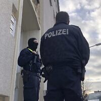Illustrative: Police officers stand outside an apartment building during a search in Osnabrueck, Germany, November 6, 2020. (Festim Beqiri/TV7News/dpa via AP)