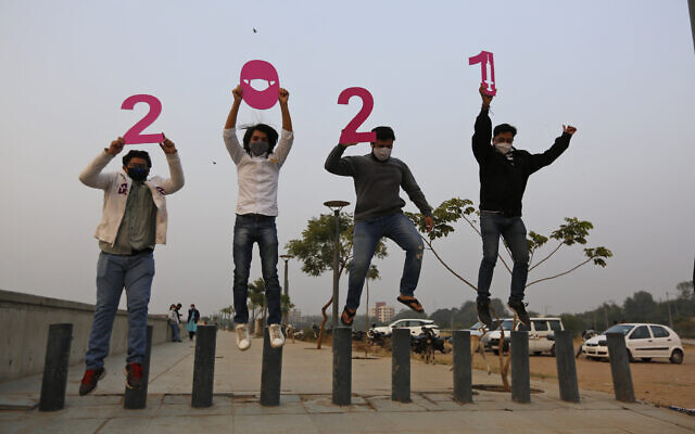 People hold cutouts to welcome the New Year in Ahmedabad, India, December 31, 2020. (AP Photo/Ajit Solanki)