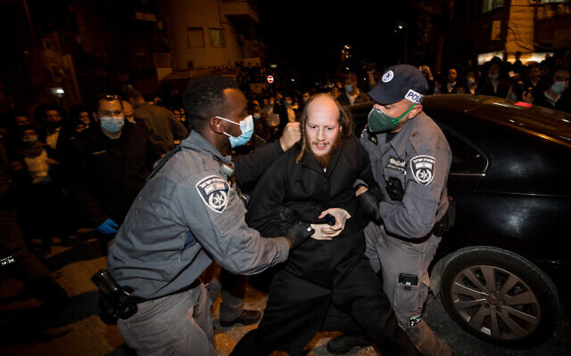 Ultra-Orthodox Jewish men scuffle with Israeli police as they protest against the new contractions work for the Jerusalem Light Rail, December 7, 2020. (Yonatan Sindel/Flash90)