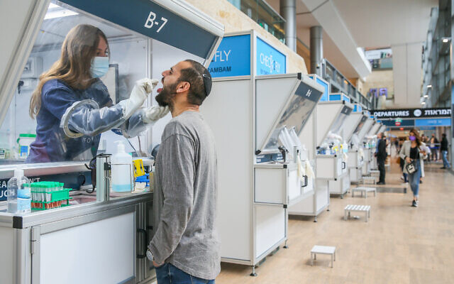 A technician collects nasal swab samples for COVID-19 at the coronavirus lab, at Ben-Gurion International Airport on December 14, 2020. (Yossi Aloni/Flash90)