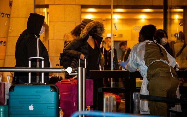 Passengers who arrived on a flight from England arrive at the Dan Panorama Hotel in Jerusalem, used as a quarantine facility, on December 20, 2020. (Yonatan Sindel/Flash90)