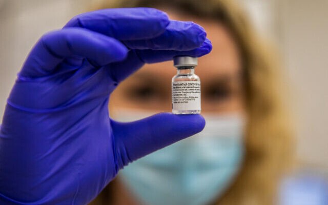A Maccabi Healthcare Services staffer holds up a vial of the Pfizer vaccine against COVID-19. (Yossi Aloni/Flash90)