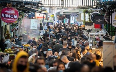 People wearing face masks shop at the Mahane Yehuda Market in Jerusalem on December 25, 2020. (Yonatan Sindel/Flash90)
