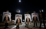 Demonstrators holds placards showing Ahuvia Sandak as they protest against his death in a car crash during a police chase last week, at Rabin Square in Tel Aviv on December 29, 2020. (Miriam Alster/ Flash90)